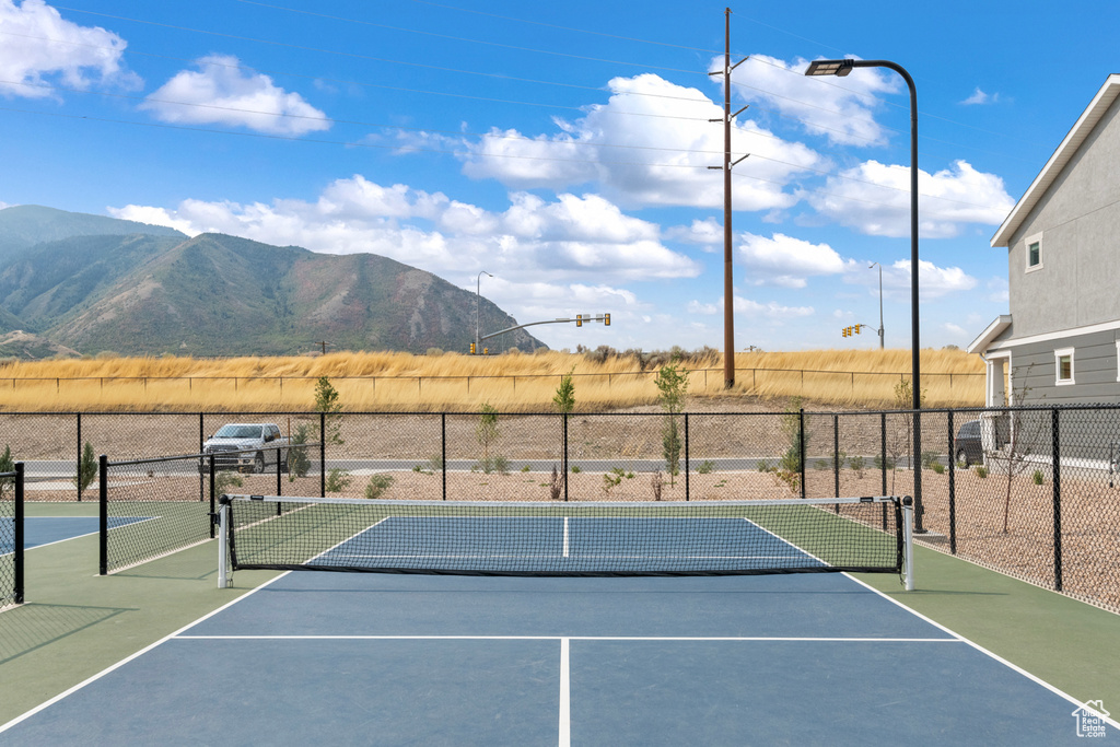 View of sport court featuring fence and a mountain view