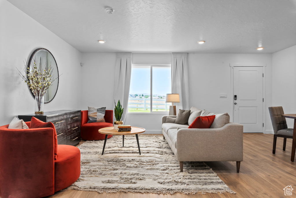 Living area with baseboards, recessed lighting, a textured ceiling, and wood finished floors