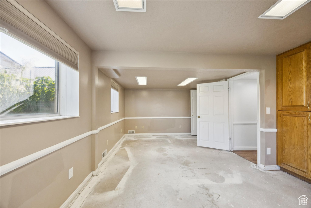 Basement with baseboards and plenty of natural light