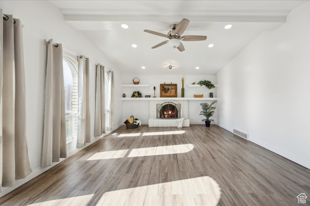Unfurnished room with ceiling fan, visible vents, a brick fireplace, wood finished floors, and recessed lighting