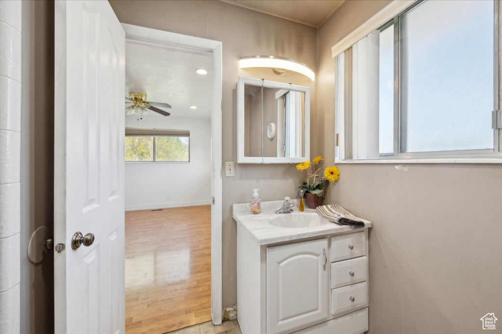 Bathroom featuring vanity, wood finished floors, baseboards, recessed lighting, and a ceiling fan