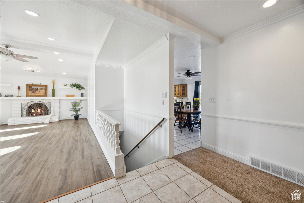 Corridor with tile patterned flooring, recessed lighting, an upstairs landing, visible vents, and ornamental molding