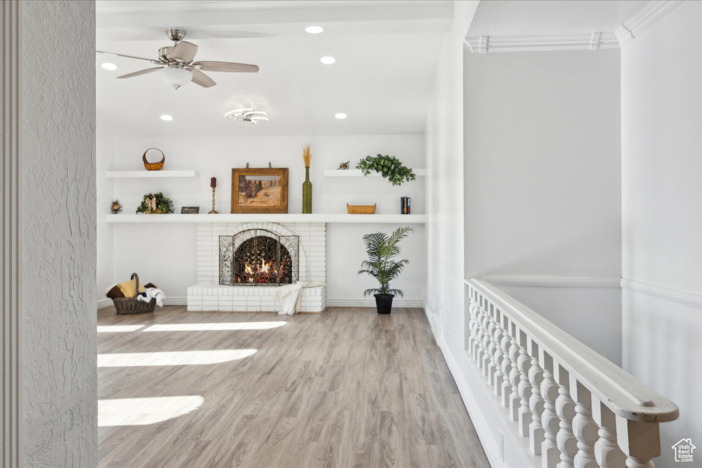 Unfurnished living room with recessed lighting, a ceiling fan, wood finished floors, and a fireplace