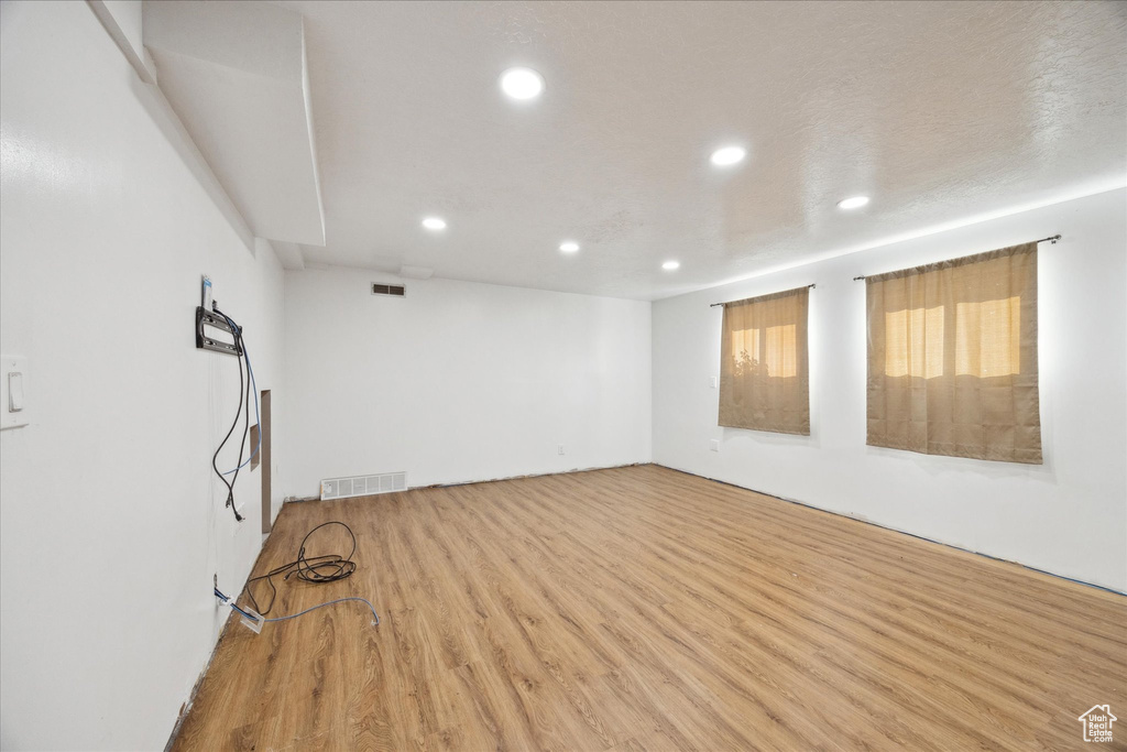 Empty room featuring recessed lighting, visible vents, and wood finished floors