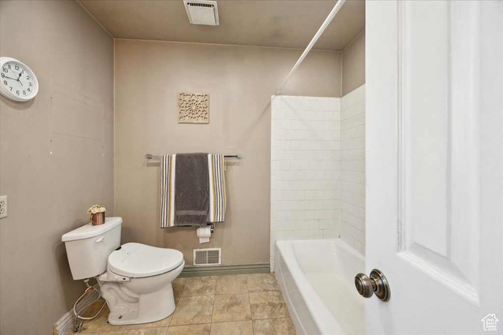 Bathroom featuring visible vents, baseboards, shower / tub combination, and toilet