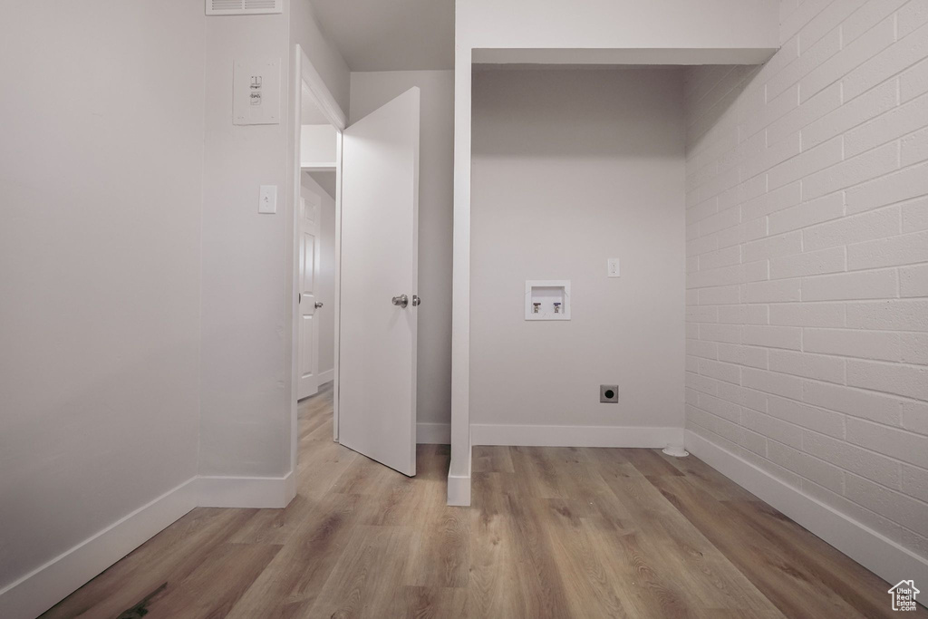 Clothes washing area with laundry area, baseboards, light wood-type flooring, washer hookup, and hookup for an electric dryer