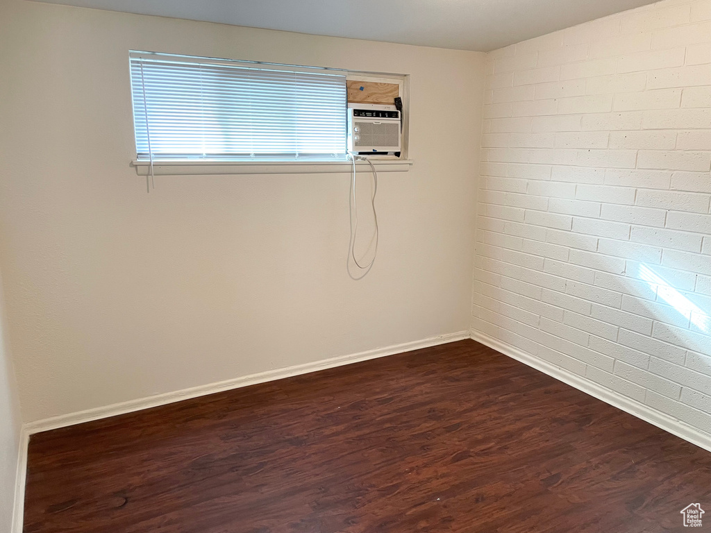 Unfurnished room with dark wood-type flooring and baseboards
