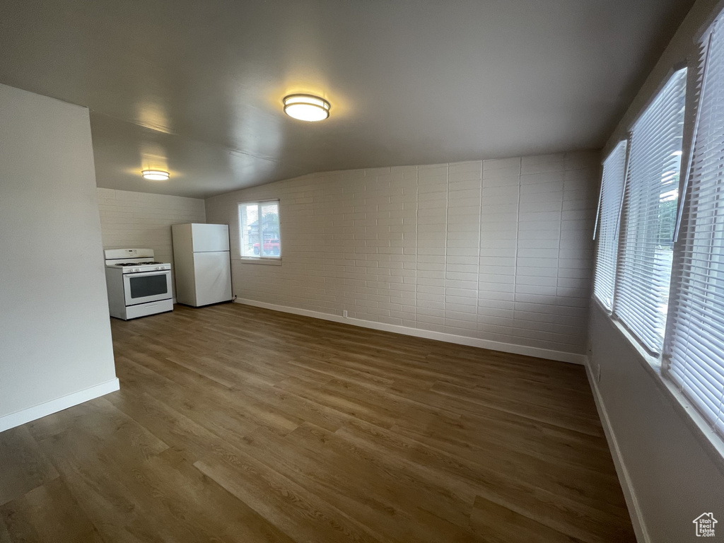 Interior space with baseboards and dark wood-style flooring