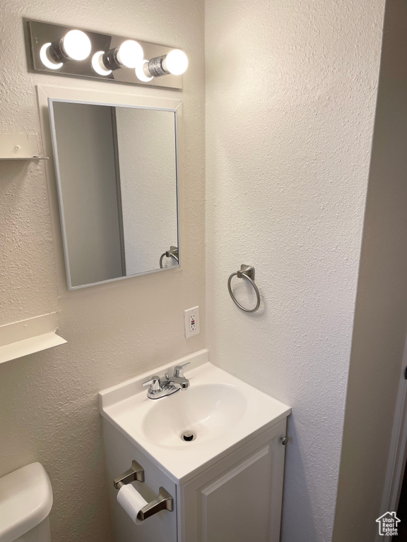 Half bath featuring vanity and toilet