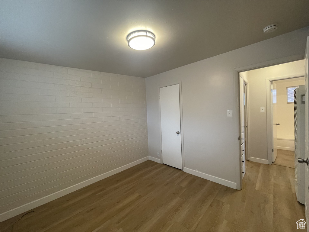 Unfurnished bedroom with baseboards and light wood-style flooring