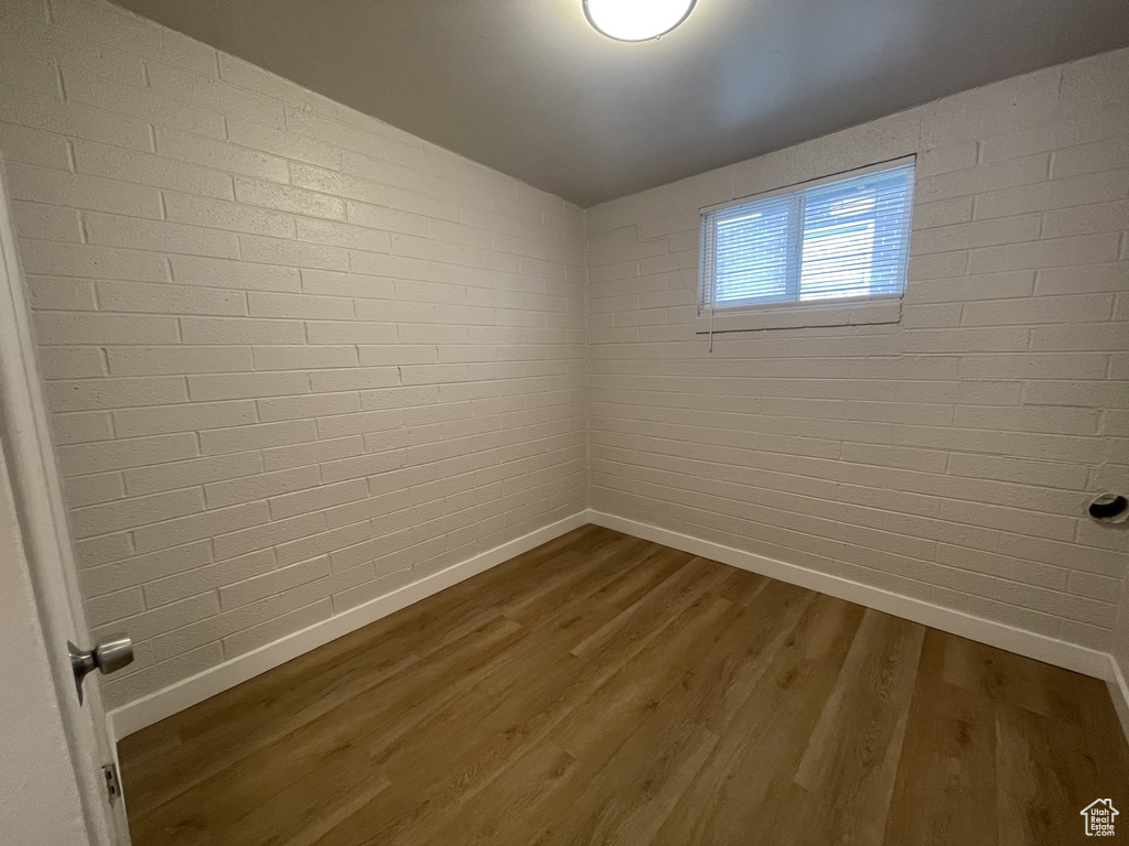Empty room featuring baseboards and dark wood-style flooring