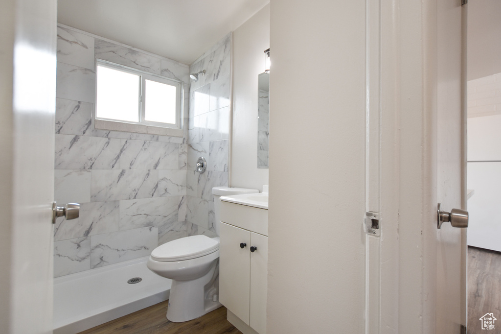 Bathroom with vanity, a shower stall, toilet, and wood finished floors