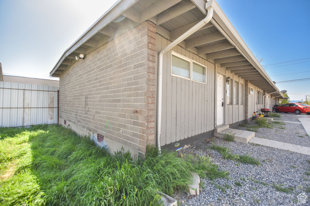View of side of home featuring brick siding and crawl space