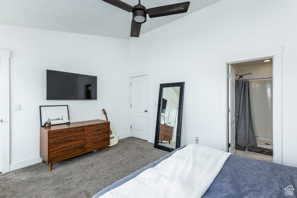 Carpeted bedroom featuring baseboards, a ceiling fan, and connected bathroom