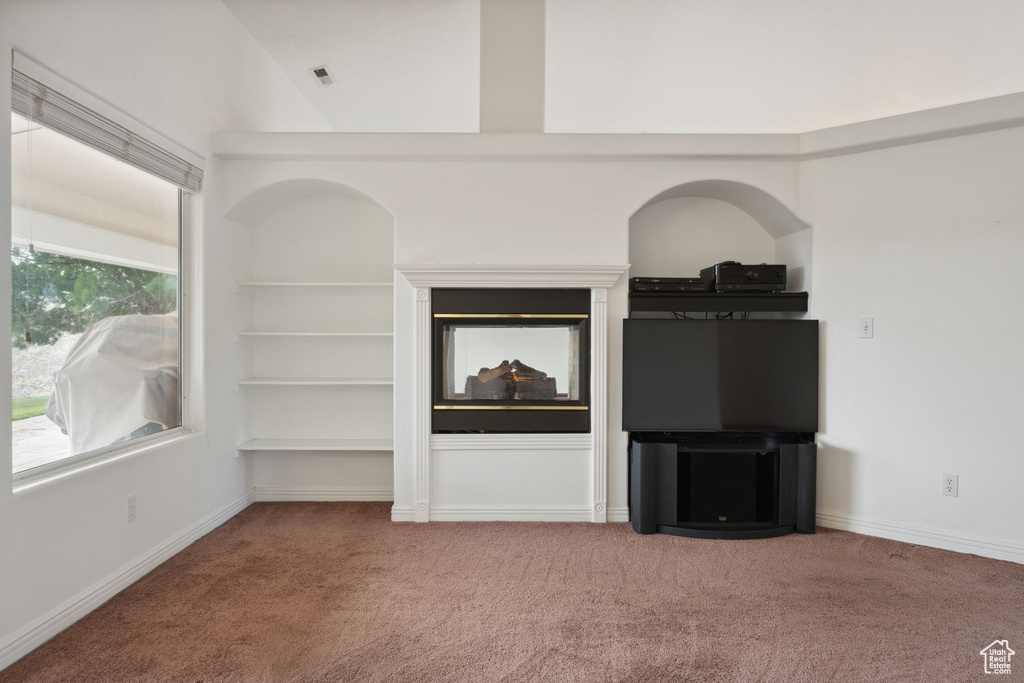 Unfurnished living room with baseboards and carpet