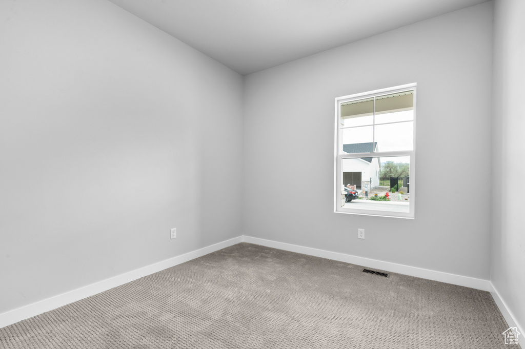 Carpeted empty room with baseboards