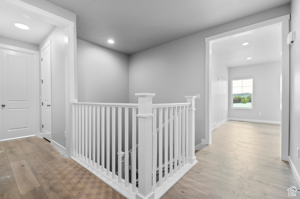 Corridor featuring an upstairs landing, hardwood / wood-style flooring, recessed lighting, and baseboards
