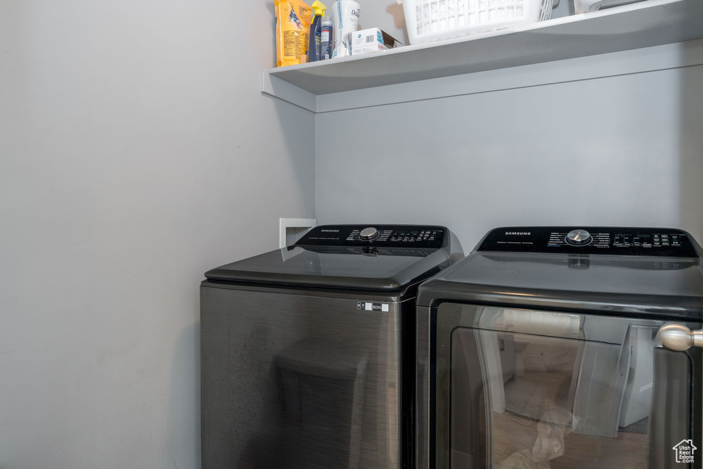 Clothes washing area featuring laundry area and washing machine and dryer