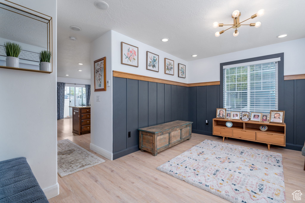 Interior space with wainscoting, recessed lighting, wood finished floors, and a notable chandelier