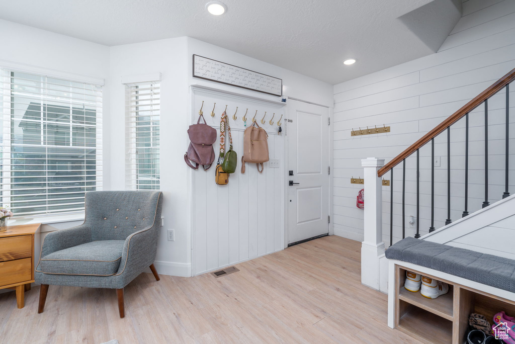 Foyer with stairs, recessed lighting, baseboards, wood finished floors, and visible vents