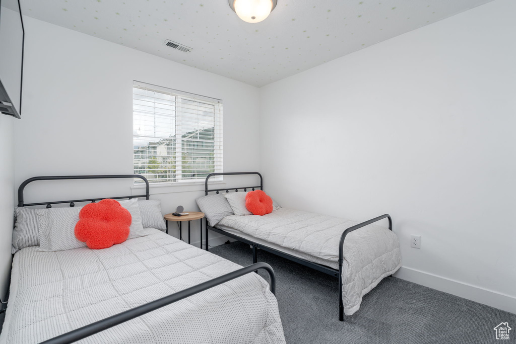 Carpeted bedroom featuring baseboards and visible vents