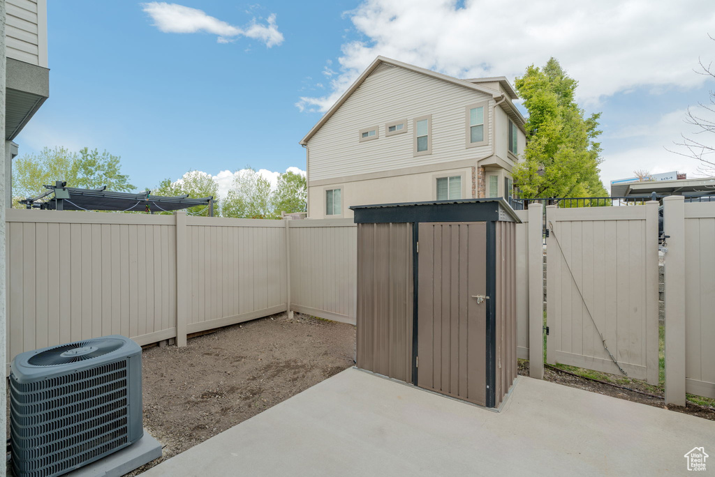 View of patio with a fenced backyard, a gate, and central AC