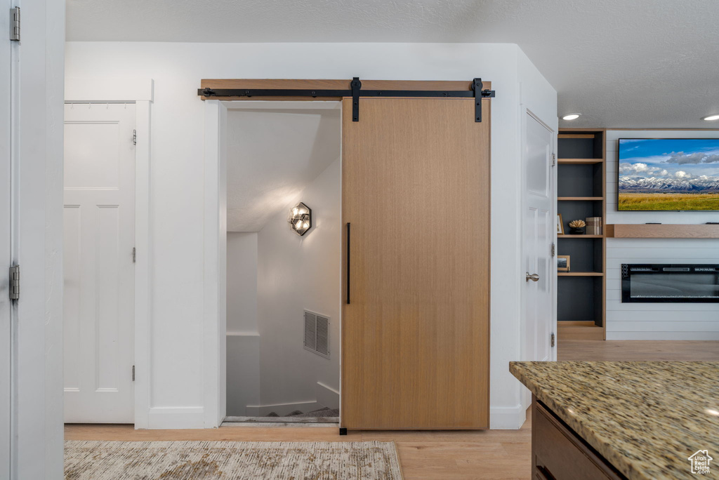 Interior space with visible vents, wood finished floors, a fireplace, baseboards, and recessed lighting