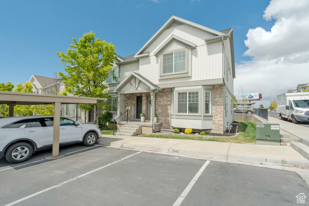 View of front of house with brick siding and uncovered parking