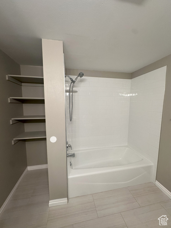 Full bath with baseboards and shower / bathtub combination