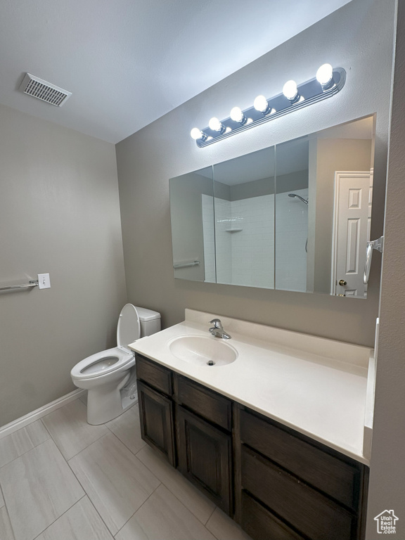Bathroom featuring vanity, walk in shower, toilet, and visible vents