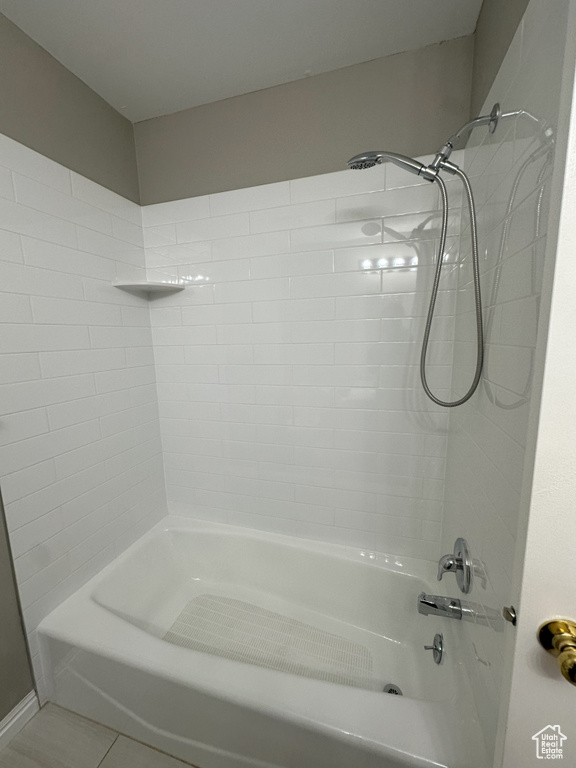 Bathroom with tile patterned floors and shower / washtub combination