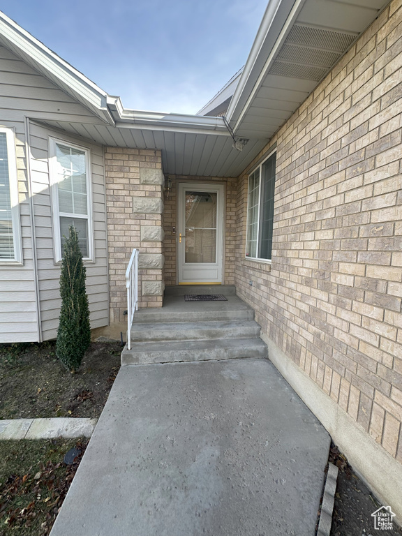 View of exterior entry with brick siding