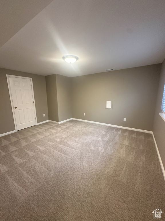 Spare room featuring baseboards and carpet