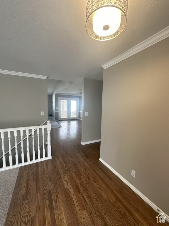 Hallway featuring baseboards, ornamental molding, and wood finished floors