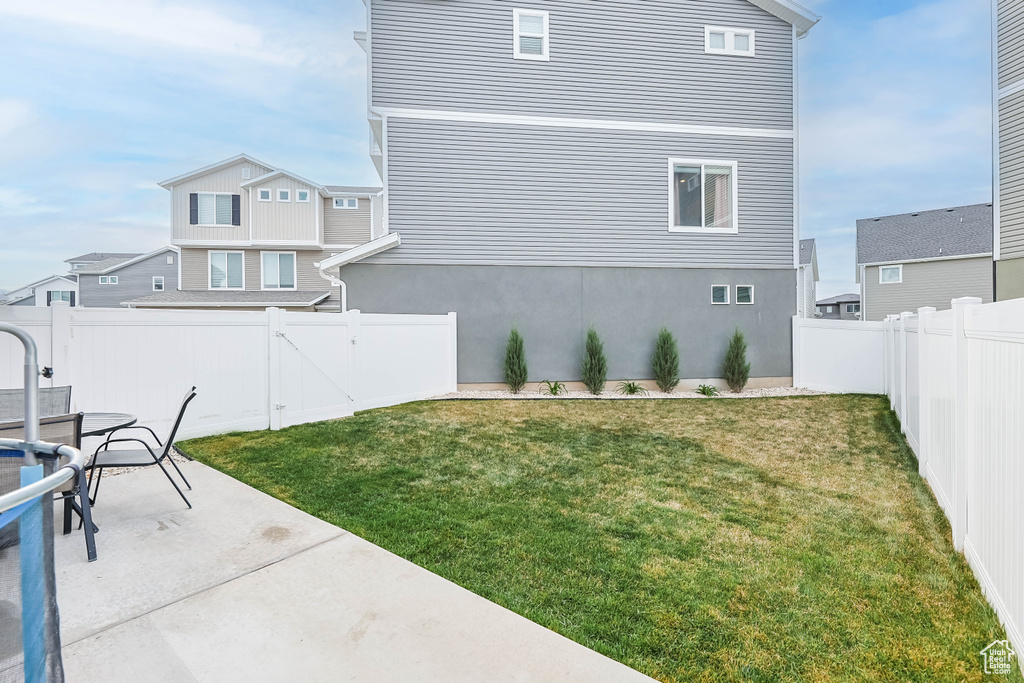 View of yard featuring a fenced backyard, a gate, and a patio area