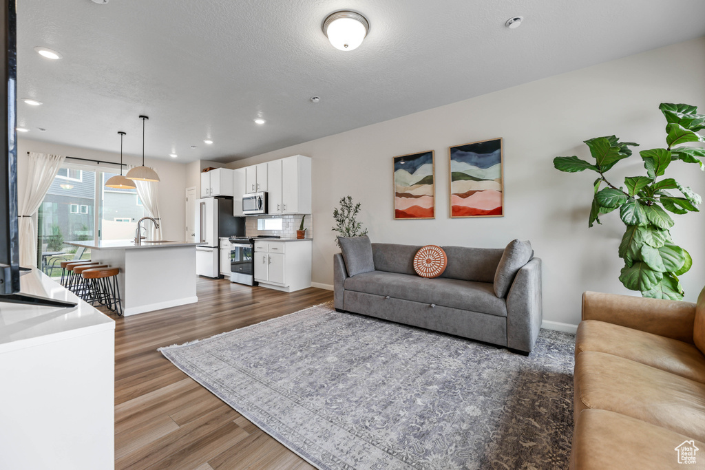 Living room with recessed lighting, baseboards, and dark wood-style flooring