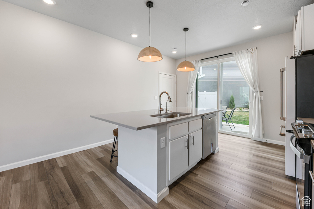 Kitchen featuring a sink, light wood-style floors, stainless steel dishwasher, and stove