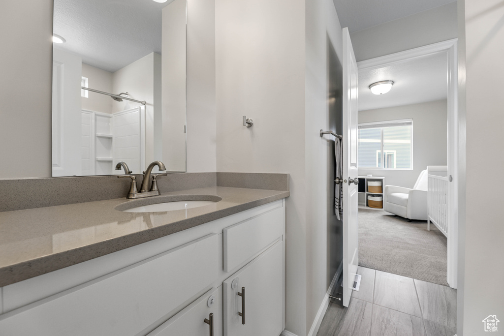 Bathroom with vanity, baseboards, and a shower