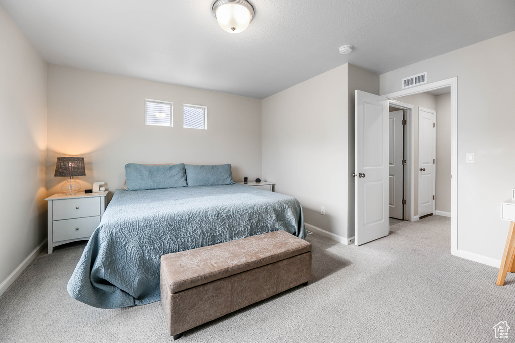 Bedroom featuring baseboards, visible vents, and light carpet