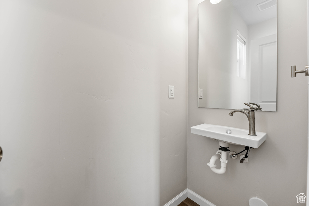 Bathroom featuring baseboards and a sink
