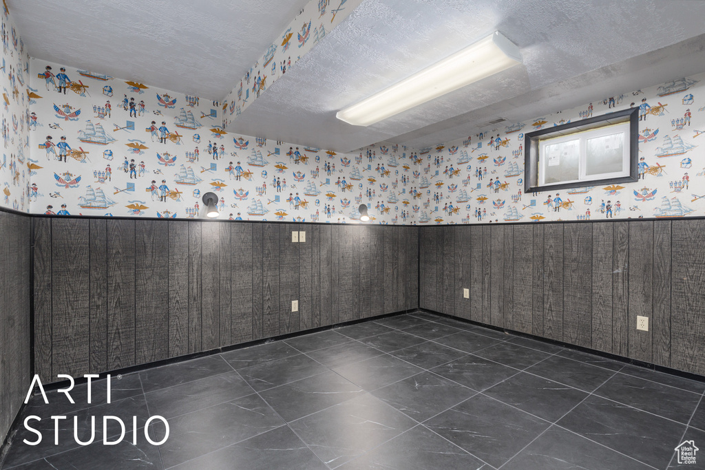 Empty room with a wainscoted wall and wallpapered walls