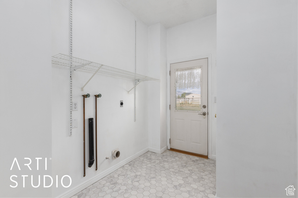 Washroom with baseboards, hookup for an electric dryer, and laundry area