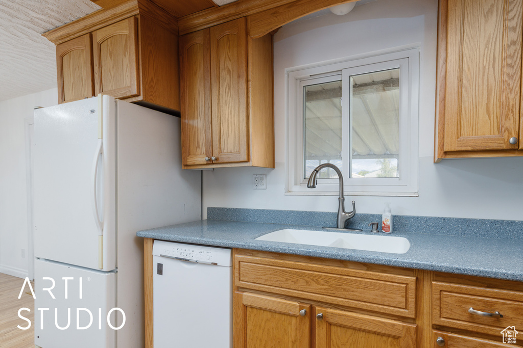 Kitchen featuring a sink and white appliances