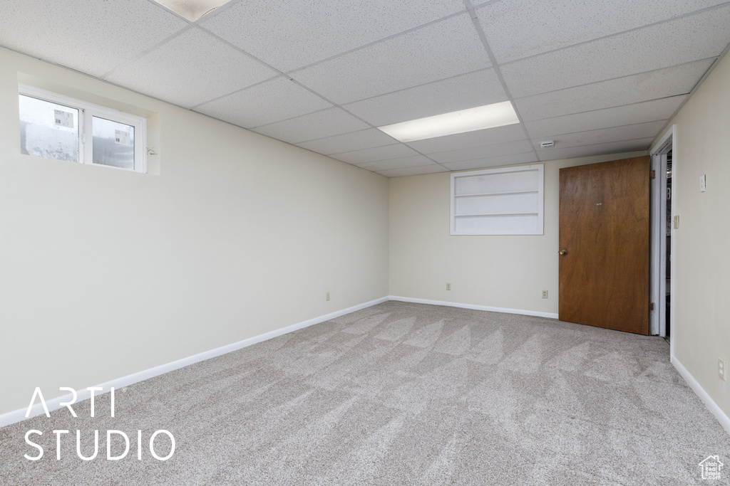 Finished basement with baseboards, carpet, and a paneled ceiling