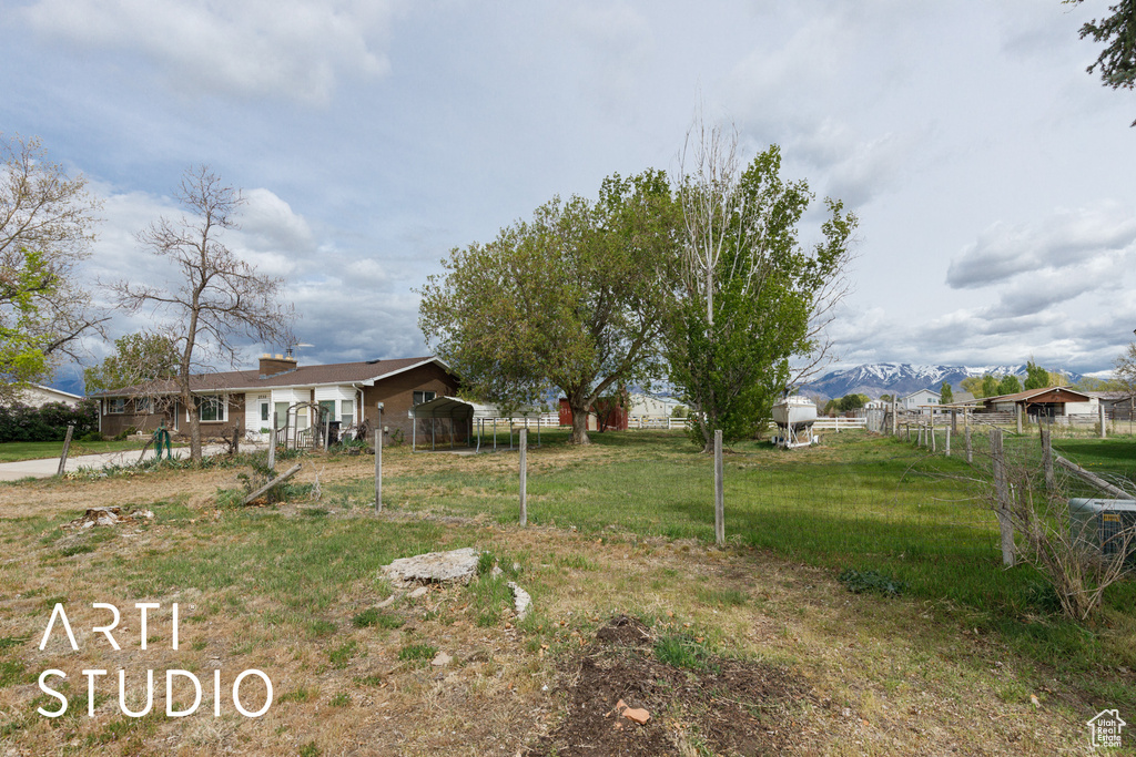 View of yard with a mountain view and fence