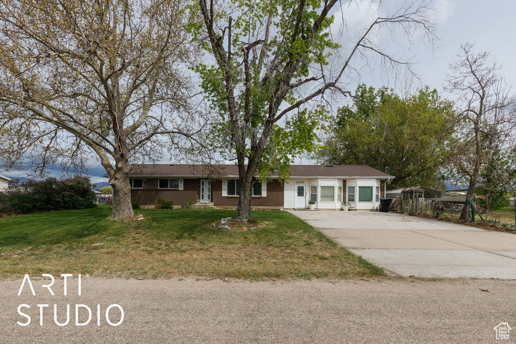 Ranch-style home with a front lawn and driveway