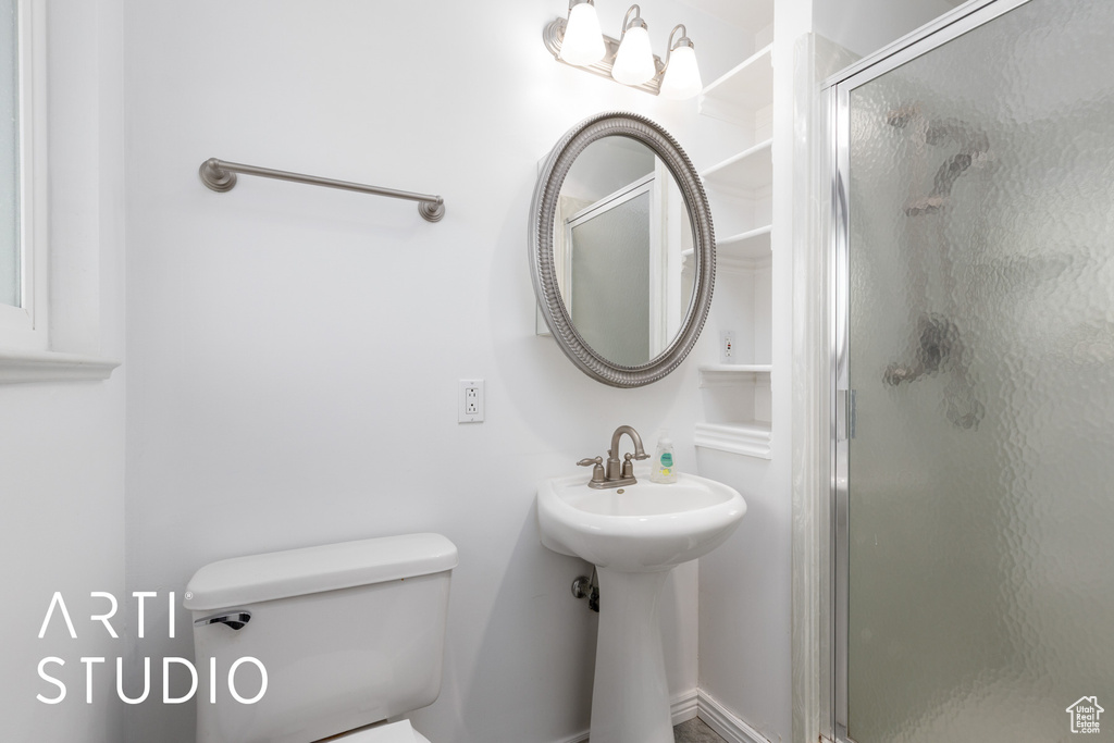 Bathroom with a sink, a shower stall, and toilet
