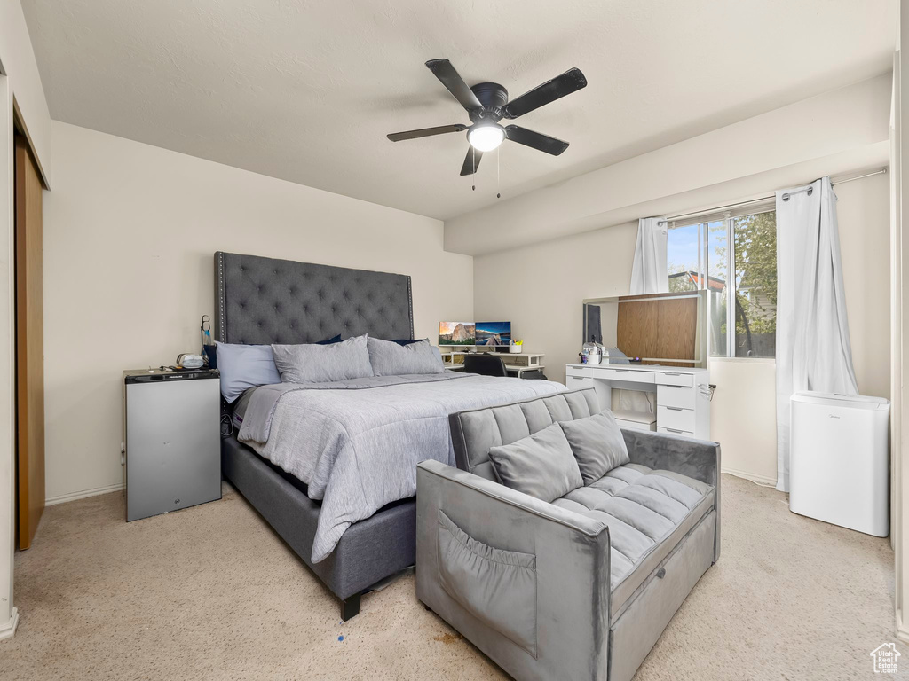 Bedroom featuring a ceiling fan and light colored carpet