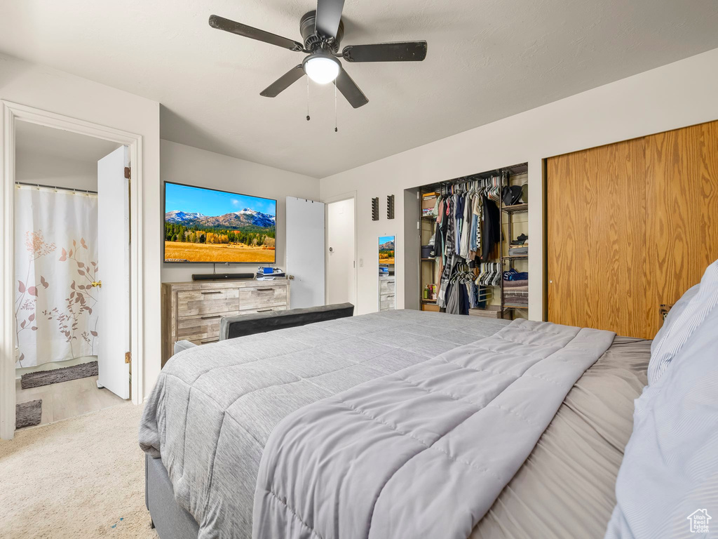Carpeted bedroom with a ceiling fan and connected bathroom