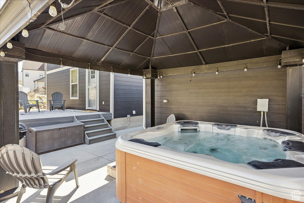 View of patio with a hot tub and a gazebo